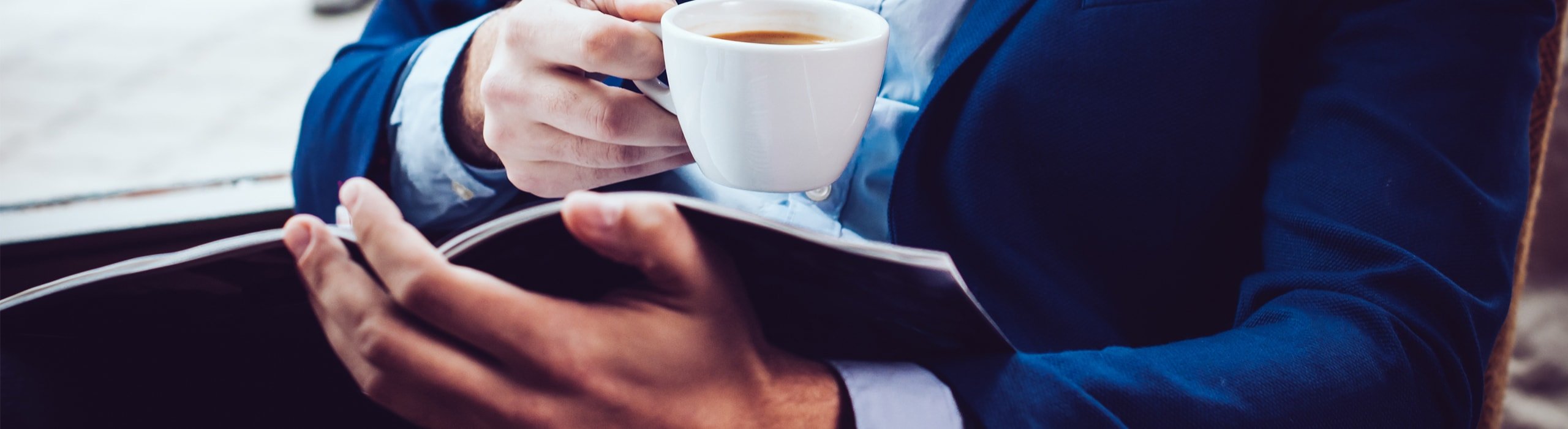 close up of business man drinking coffee and reading information