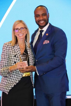 gentleman presenting award to a woman business broker