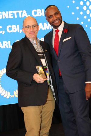 award winner on stage holding award smiling for portrait