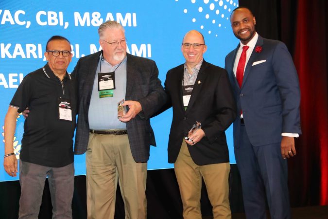 multiple business award winners on stage smiling for portrait