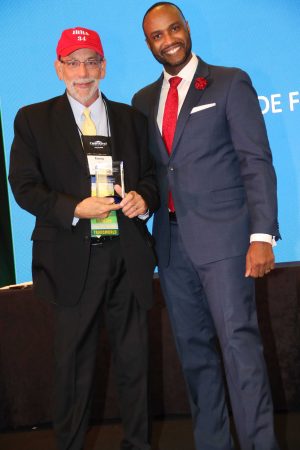 Randy smiling on stage with his award