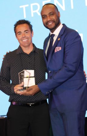 award winner taking portrait on stage with award and presentor