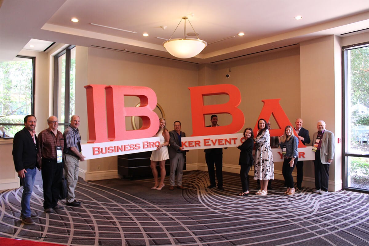 business brokers hold up letters from the ibba sign