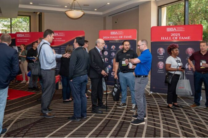 conference attendees mingle around the award winner banners
