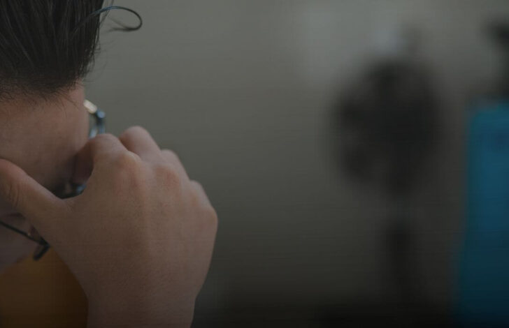 A stressed man with a hand on his face